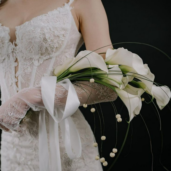 Bridal bouquet of calla lilies with beads and bear grass